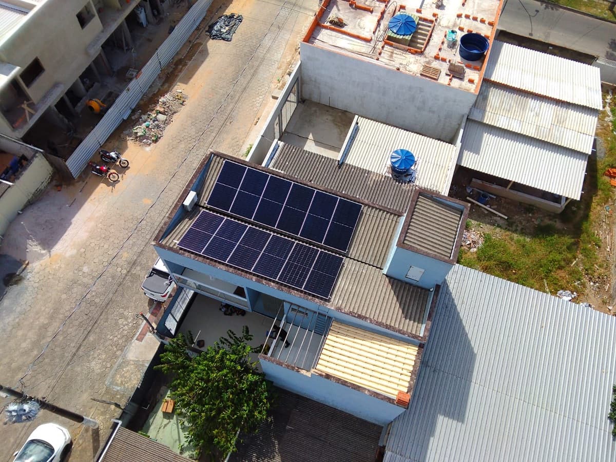 Vista aérea de residência com dois conjuntos de painéis solares no telhado