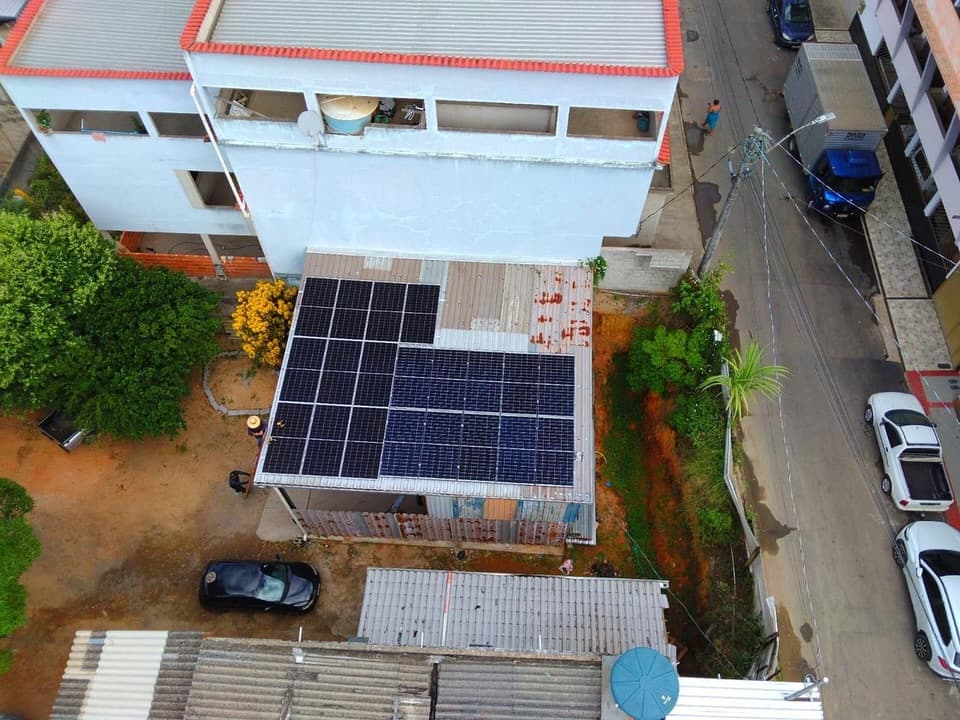Vista aérea de sistema solar instalado em telhado de imóvel ao lado da rua